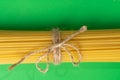 spaghetti on a green background, tied with a rope, Royalty Free Stock Photo